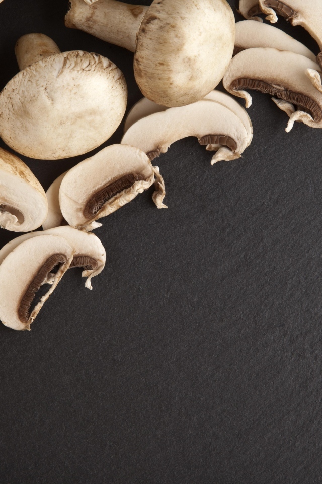 Нарезанные шампиньоны на сером столе
