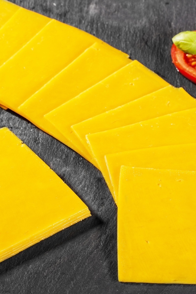 Ломтики сыра с помидором на столе