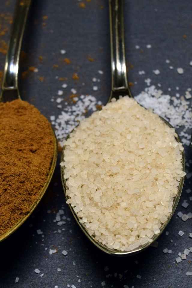 Три ложки со специями на сером столе