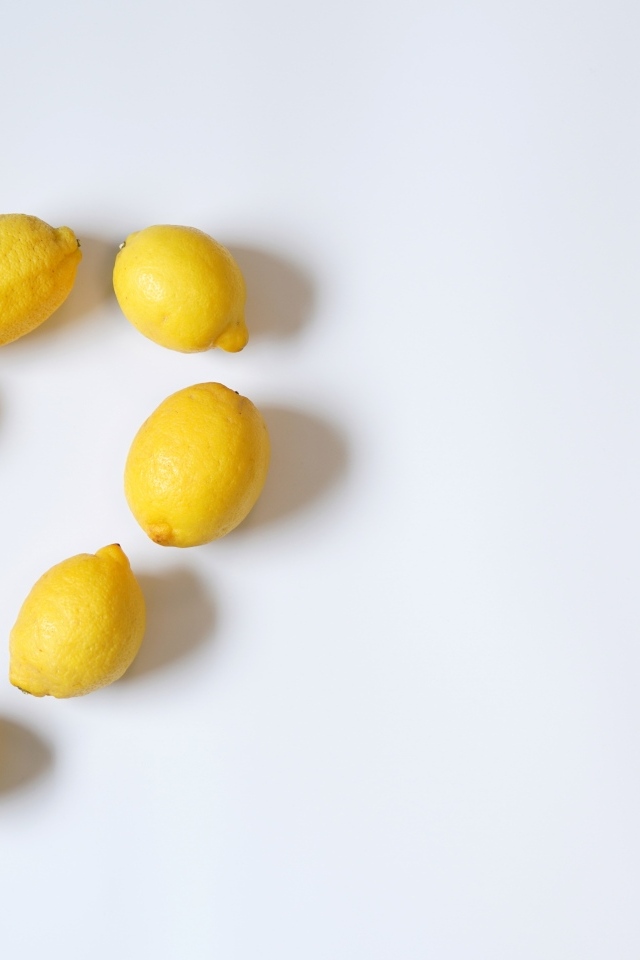 Сердце из желтых лимонов на сером фоне с конфетами