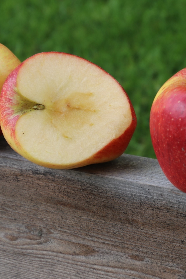 Красные яблоки лежат на деревянной доске