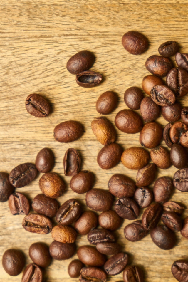 Жареные кофейные зерна на деревянном столе