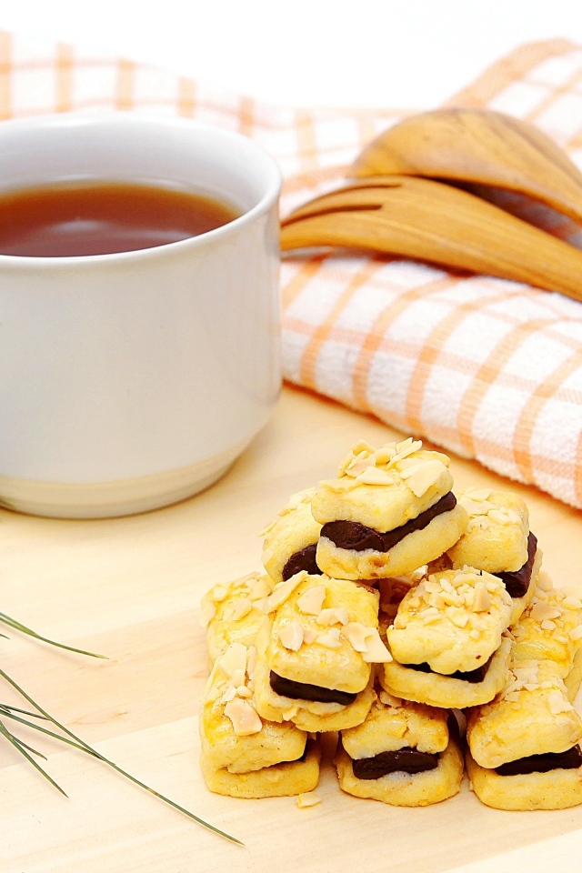 Печенье с чашкой чая и сосновой шишкой на столе