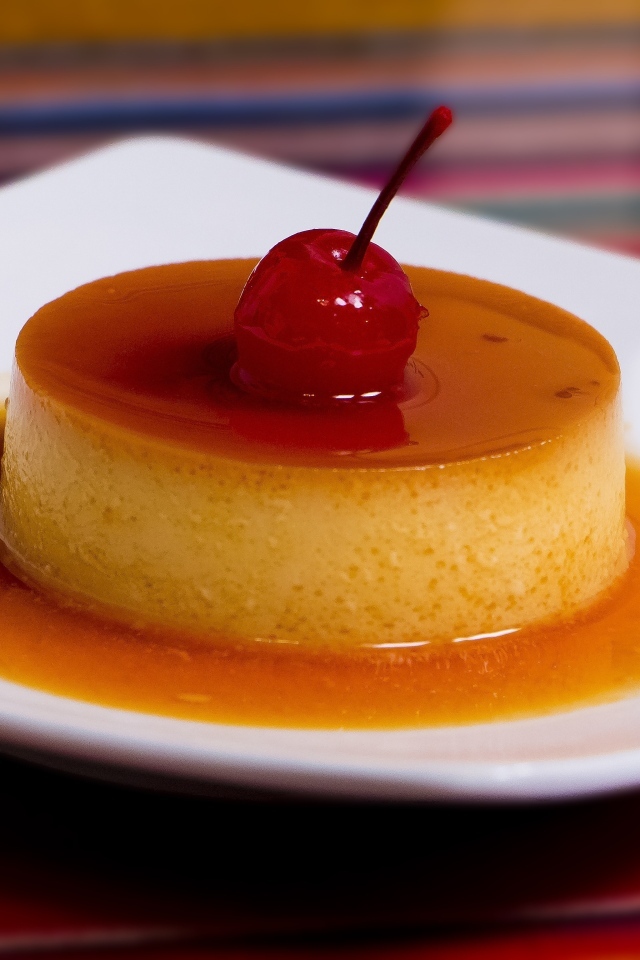 Десерт с сиропом и черешней на белой тарелке