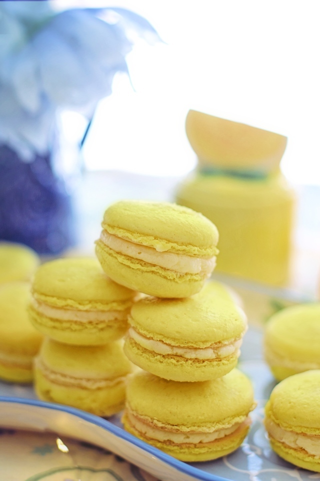 Десерт макарунс желтого цвета на тарелке на столе