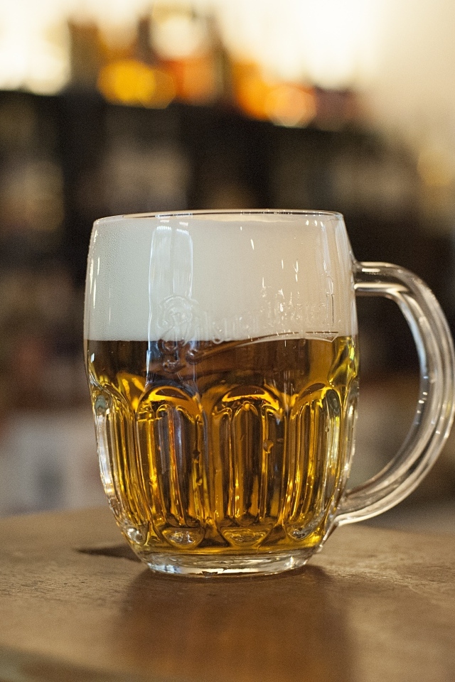 Бокал пива с пеной на столе