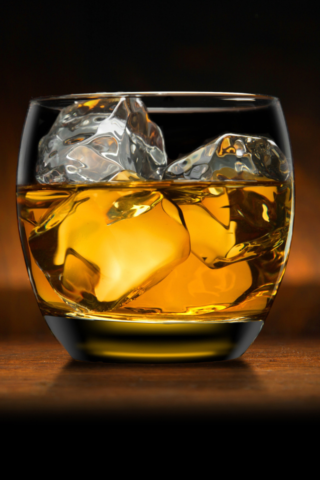 Стакан виски со льдом на столе