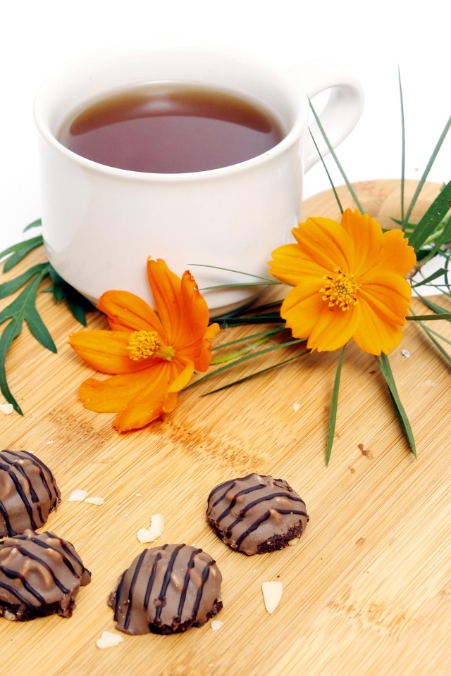 Чашка чая на деревянной доске с конфетами