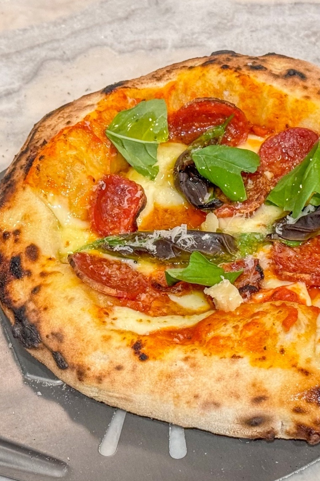 Маленькая пицца на лопате на столе