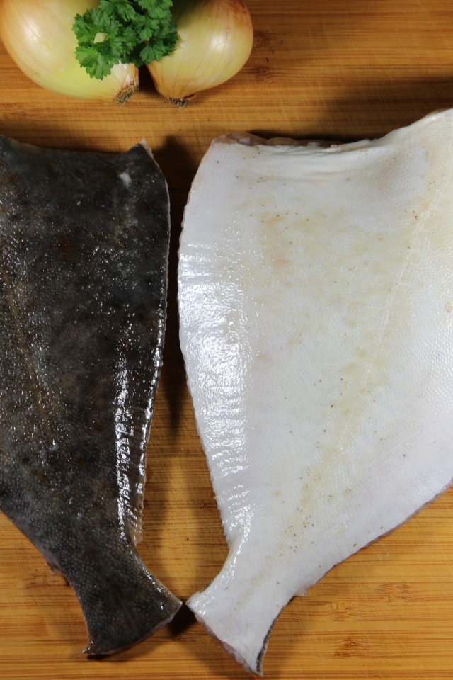 Камбала на доске с луком и ножом