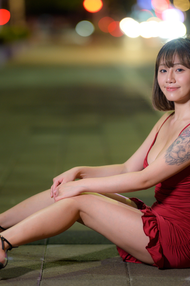 Азиатка с татуировкой на руке в красном платье