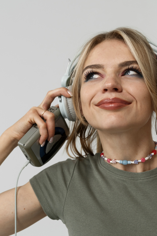 Красивая девушка в наушниках с плеером