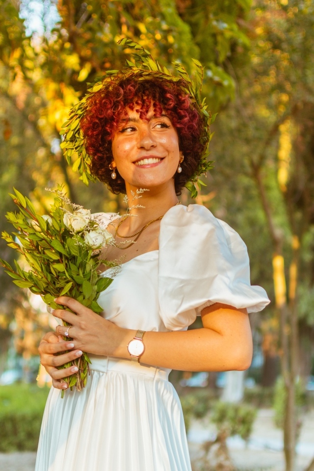 Красивая улыбающаяся рыжеволосая девушка с букетом