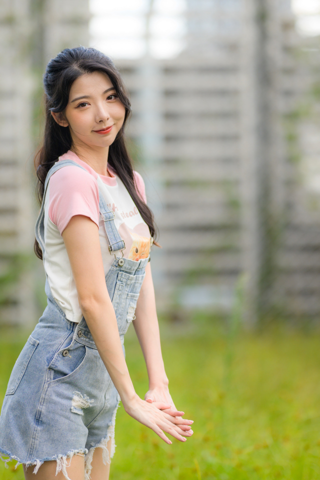 Милая девушка азиатка в джинсовом комбинезоне