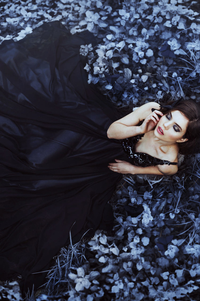 Девушка в черном платье лежит в траве