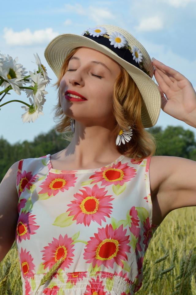 Девушка с букетом ромашек на поле