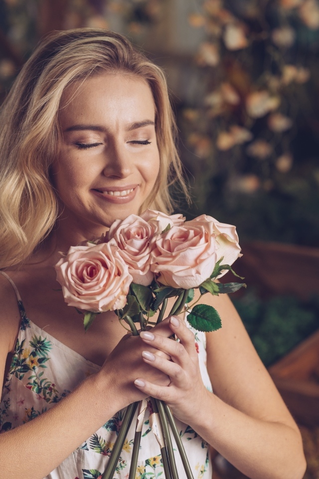 Девушка с букетом роз с закрытыми глазами