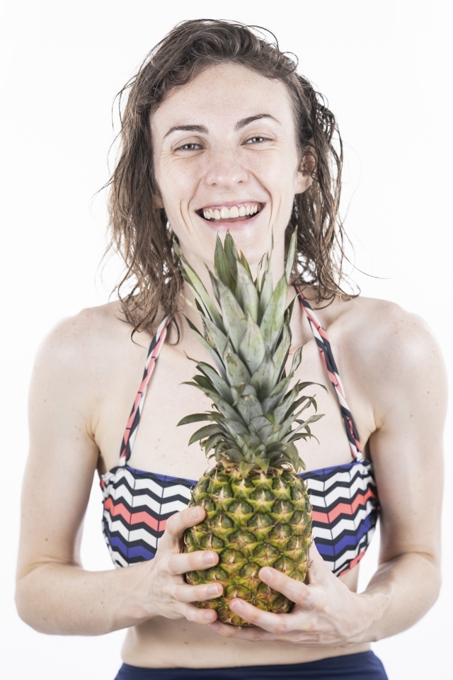 Улыбающаяся девушка с ананасом в руках