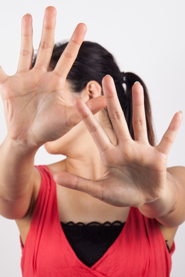 Девушка закрывает лицо руками