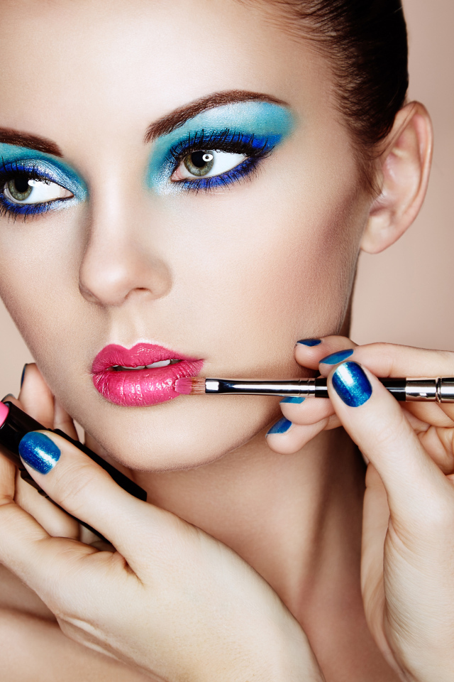 Девушке делают красивый яркий макияж