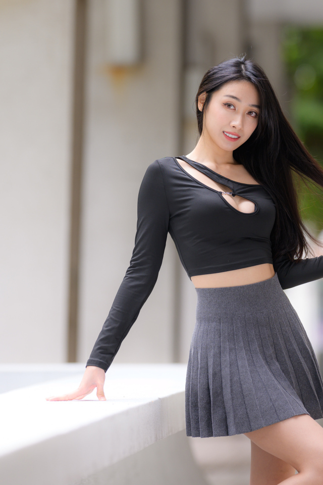 Молодая азиатка в короткой серой юбке