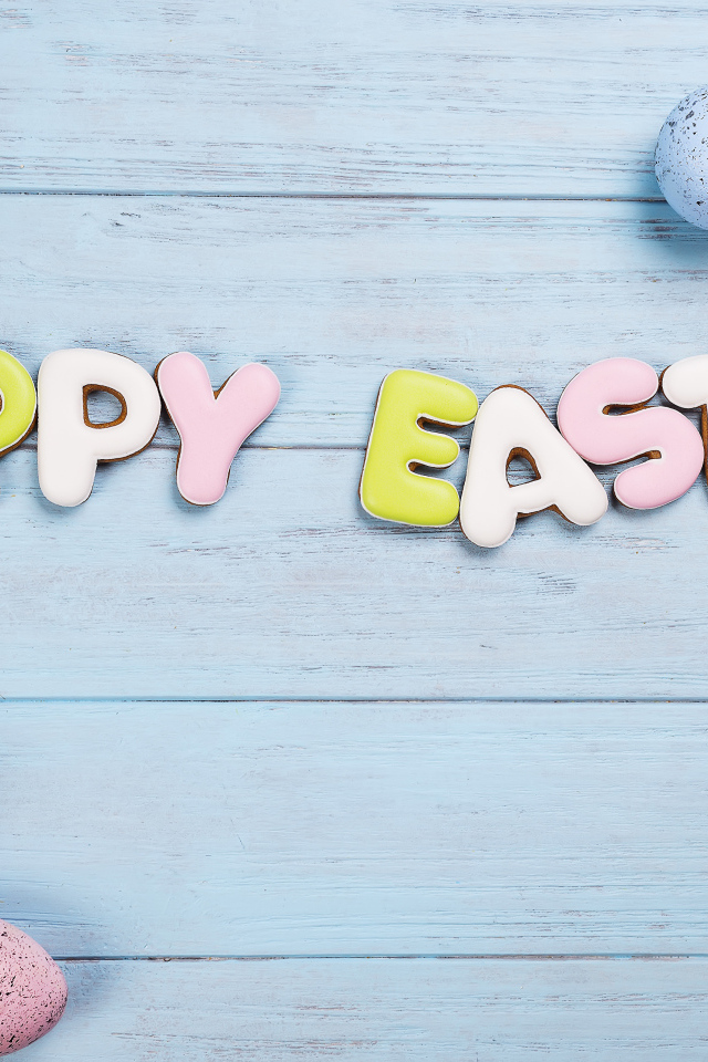 Печенье с надписью счастливой Пасхи с яйцами и цветами