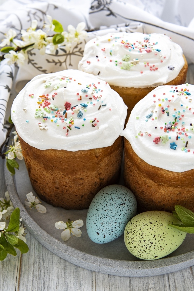 Три пасхальных кулича с яйцами на тарелке