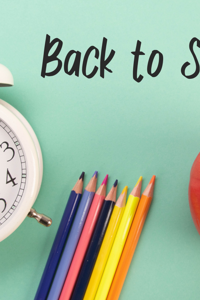 Будильник, карандаши и яблоко на фоне с надписью пора в школу