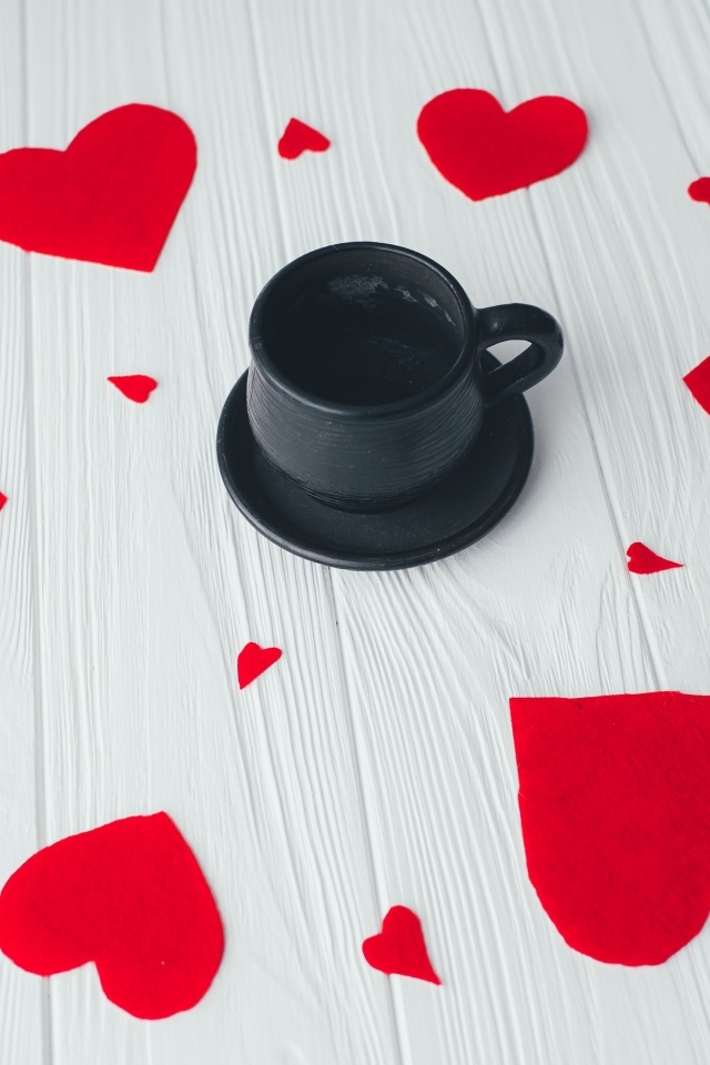 Чашка кофе с красными сердечками на столе