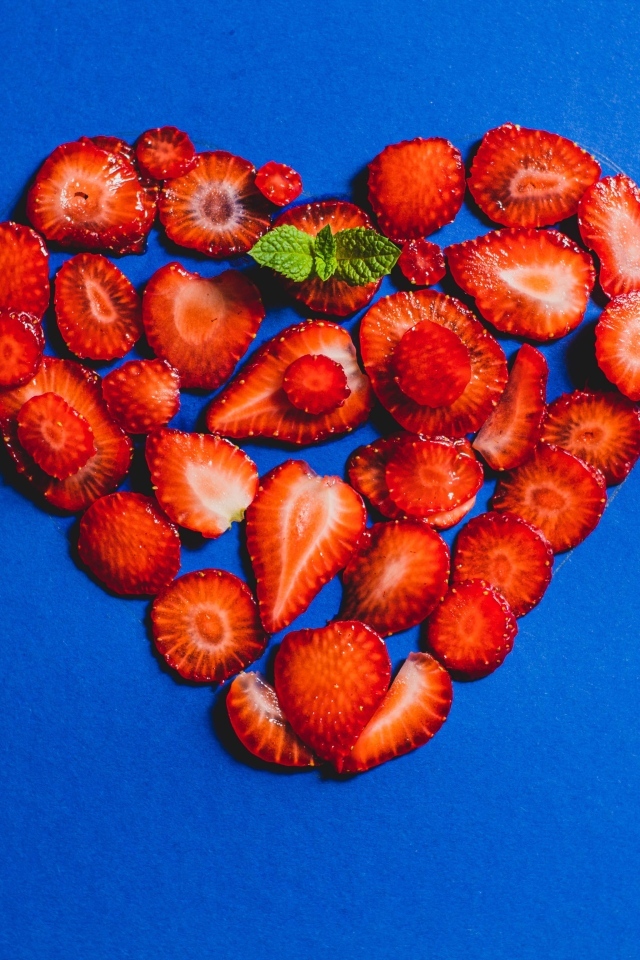Сердце из сушеной клубники на синем фоне