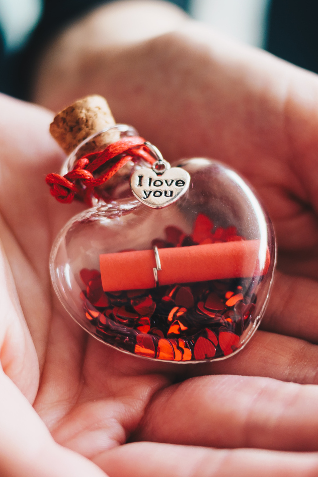 Ладони с маленький стеклянным сердечком