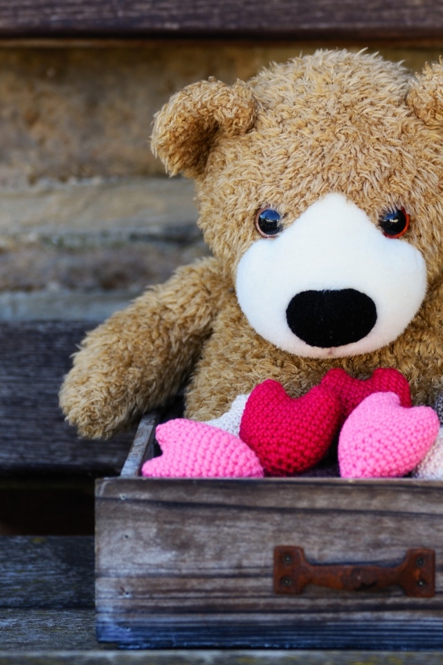 Игрушечный медвежонок с сердечками в деревянном ящике