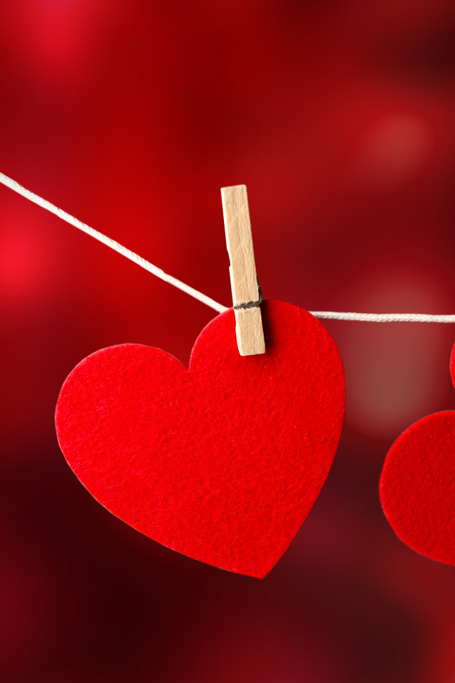 Два красных сердца висят на веревке