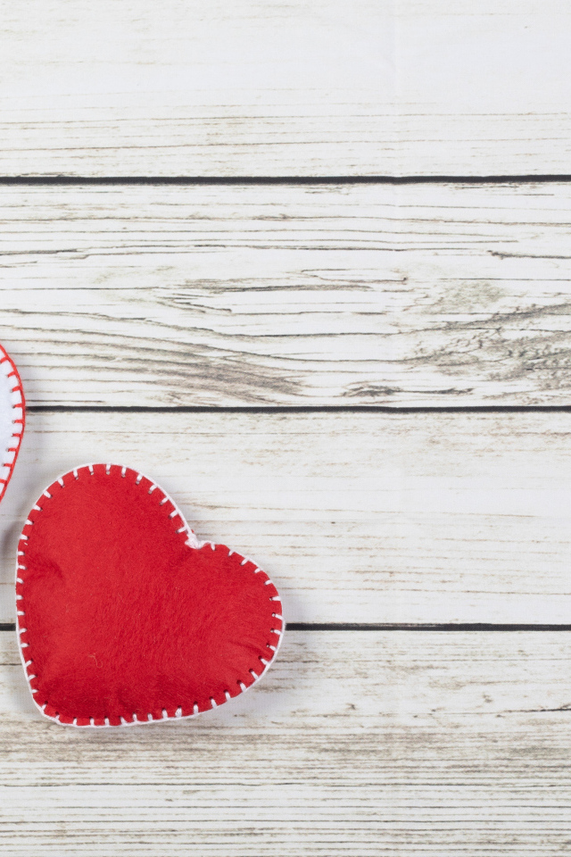 Белое и красное сшитое сердце на деревянном фоне