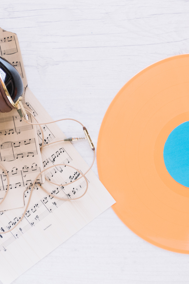 Наушники, ноты и виниловая пластинка на белом фоне