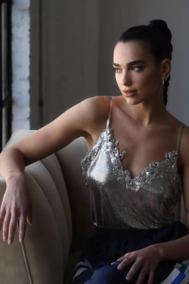 Певица Дуа Липа сидит у окна