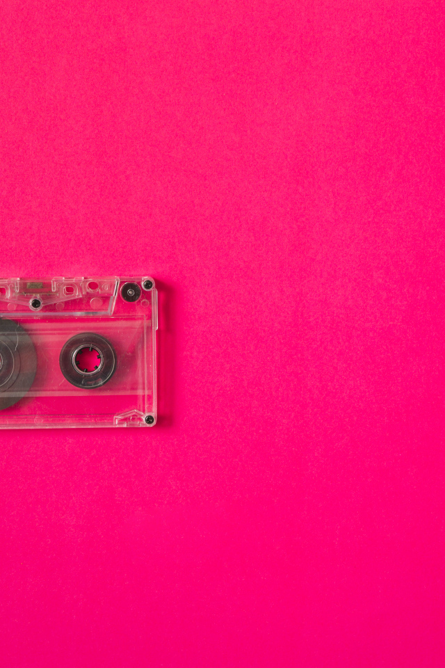 Маленькая магнитофонная кассета на розовом фоне