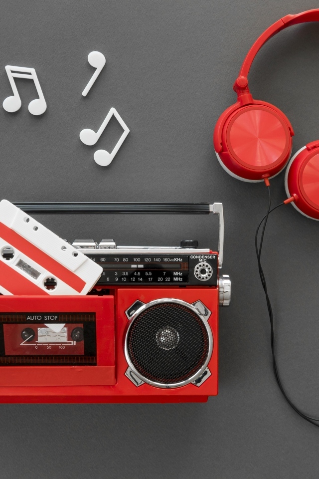 Магнитофон с кассетой, наушниками и нотами на сером фоне