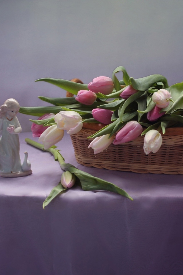 Корзина тюльпанов на столе со статуэткой