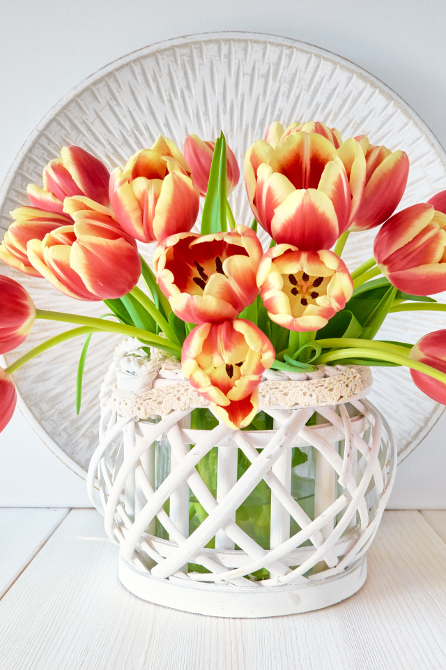 Красивый букет оранжевых тюльпанов в белой вазе на столе