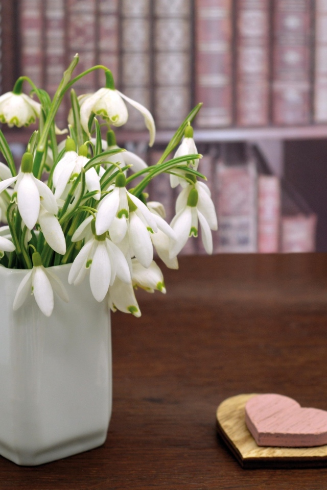 Букет белых подснежников в вазе на столе с сердечками