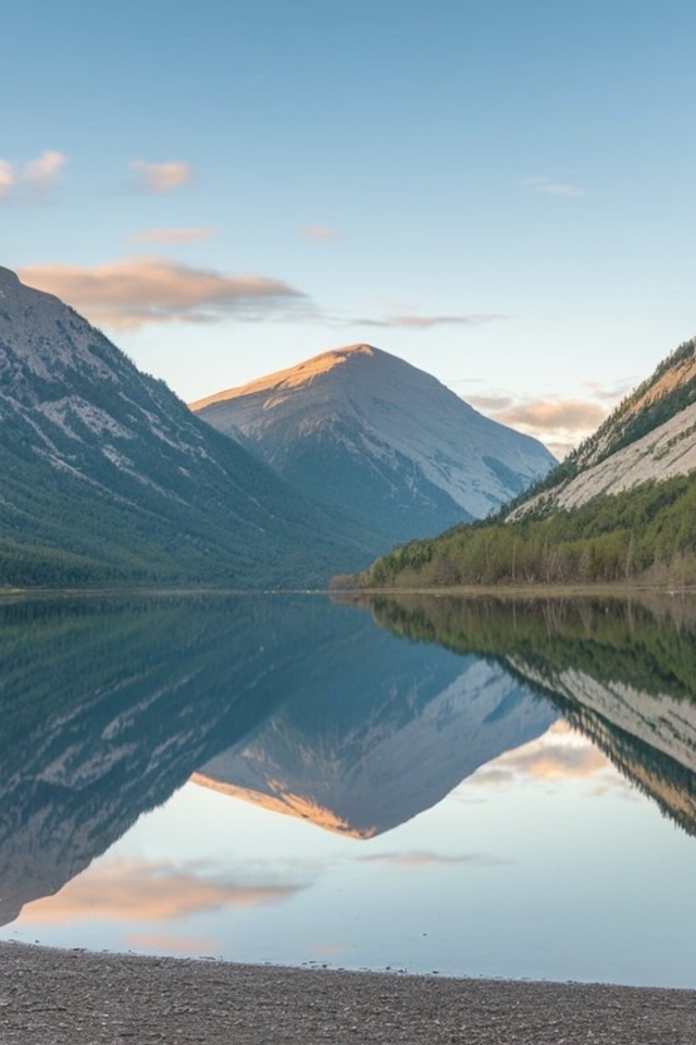 Покрытые зеленью горы отражаются в спокойной воде озера