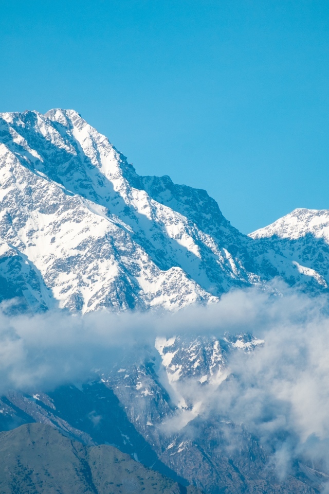 Высокие покрытые снегом горы на фоне голубого неба