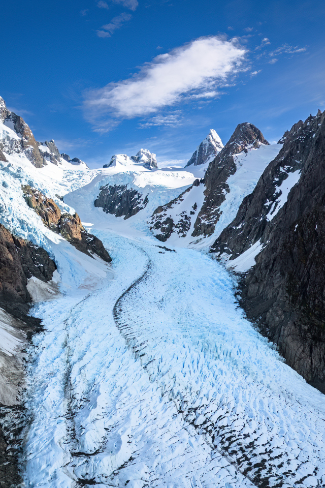 Заснеженная заледеневшая дорога между гор
