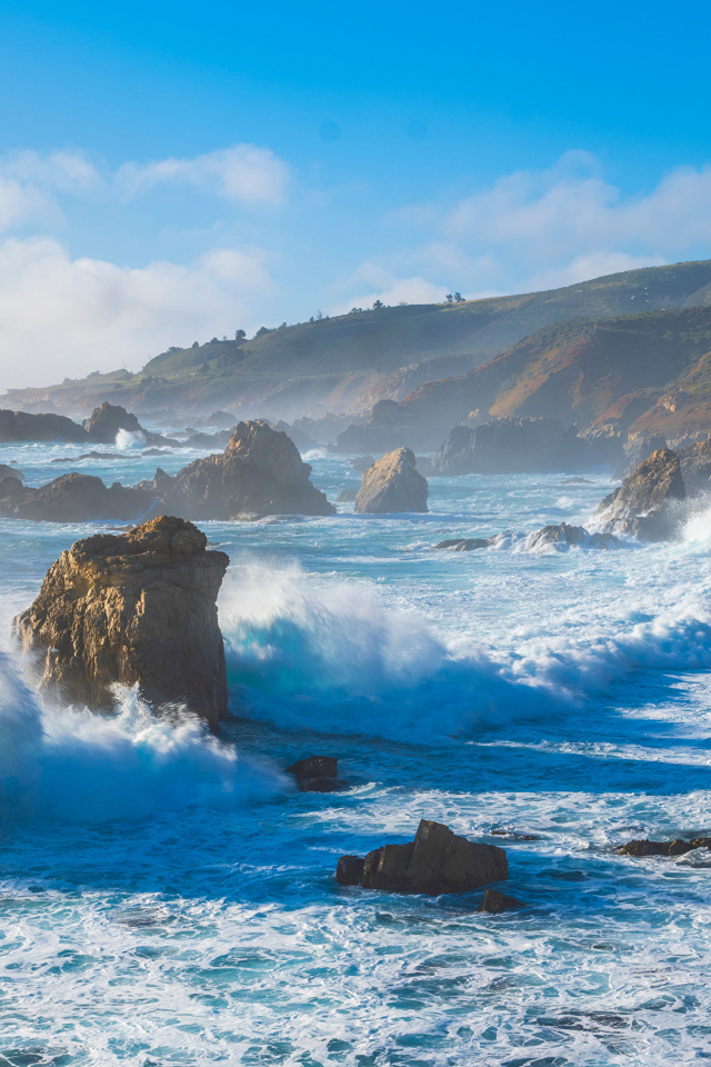 Белые бушующие волны бьются о камни 