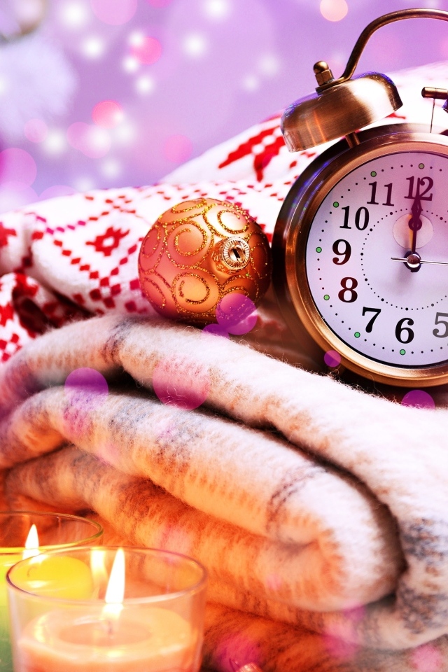 Будильник, теплый плед и зажженные свечи на праздник