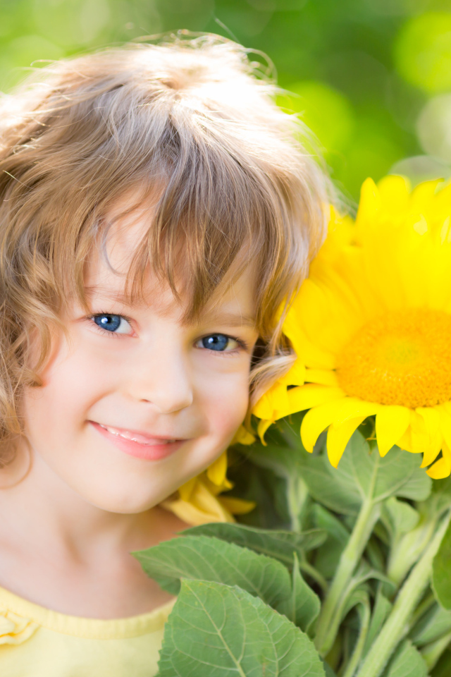 Красивая голубоглазая девочка с букетом подсолнухов