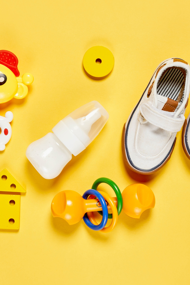 Детские игрушки и обувь на желтом фоне