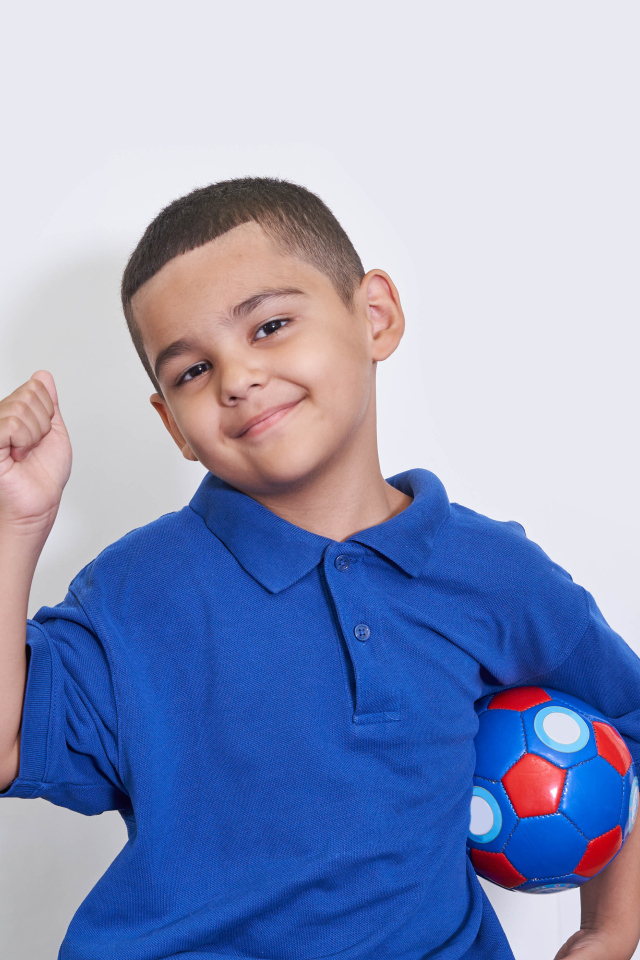 Милый мальчик с мячом на белом фоне