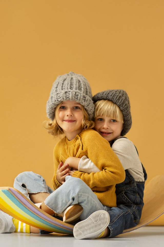 Счастливые брат и сестра в теплых шапках